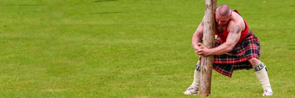 man wearing a kilt competing in highland games