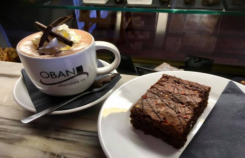 Cup of hot chocolate and a chocolate brownie on a plate